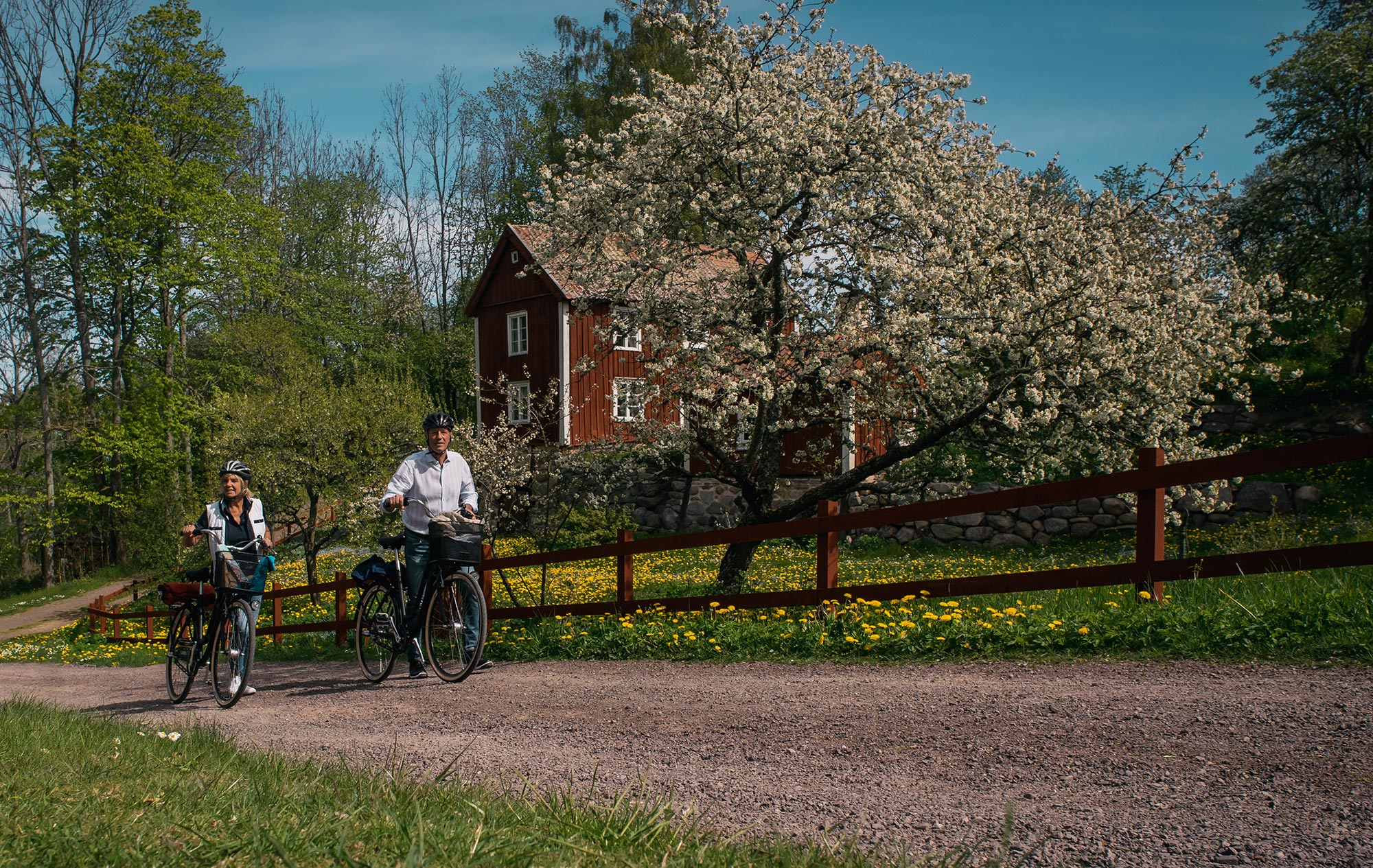 Man och kvinna cyklar i den gamla industribyn Röttle strax söder om Gränna