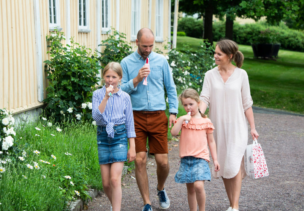 Familj äter polkagrisar i Gränna utanför Grenna Museum