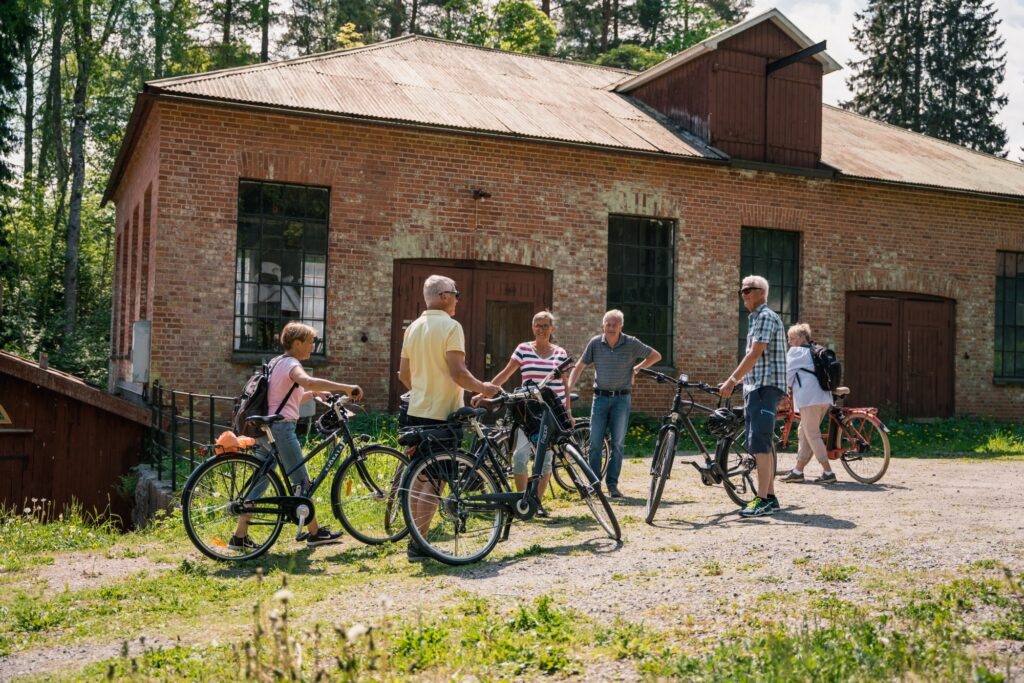 En grupp som stannar till vid en tegelbyggnad på en cykeltur